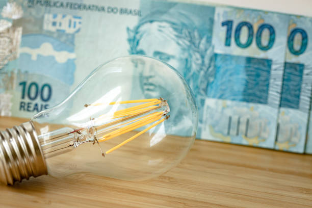 100 reales brasileños y una bombilla, concepto de aumento de los precios de la energía y la electricidad en brasil - energy bill fotografías e imágenes de stock