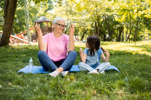 Senior woman meditating with her granddaughter