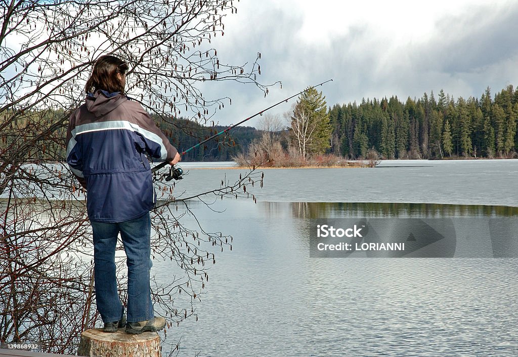 Uomo pesca in un lago - Foto stock royalty-free di Abbigliamento casual