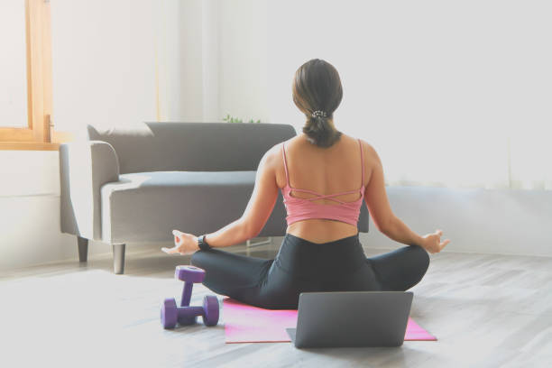 istock Woman practicing yoga at home from online classes after work. stress relief, muscle relaxation, breathing exercises, exercise, meditation. 1398690949