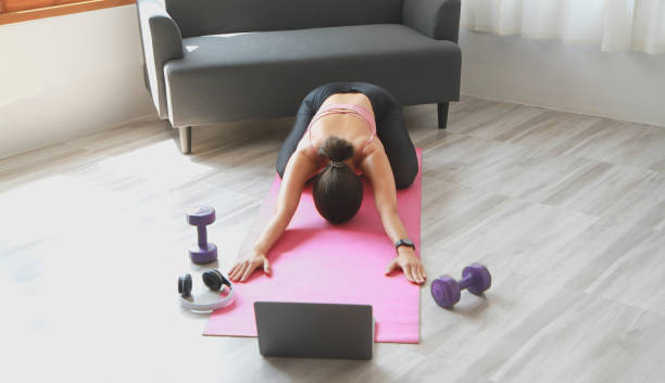 istock Woman practicing yoga at home from online classes after work. stress relief, muscle relaxation, breathing exercises, exercise, meditation. 1398690976