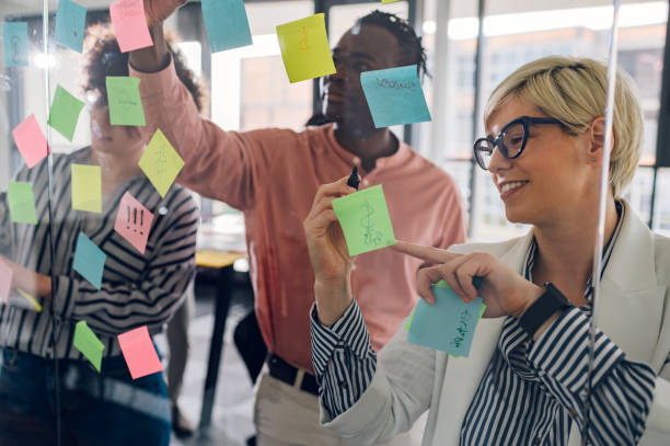 istock Multiracial team at work writing ideas on sticky notes on the glass wall 1398692459