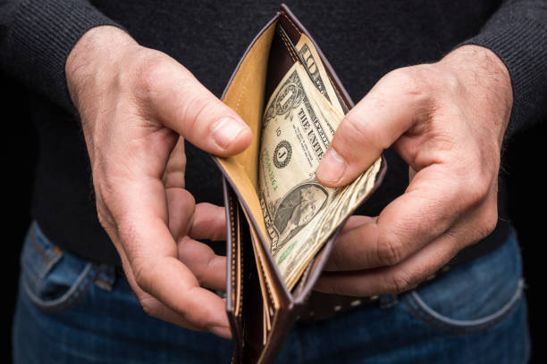 Hands holding a wallet with a small amount of US dollars, close up Hands holding a wallet with a small amount of US dollars, close up wallet photos stock pictures, royalty-free photos & images