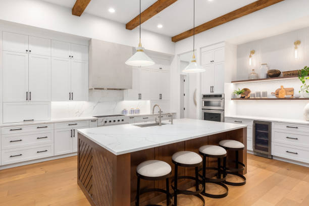beautiful kitchen in new luxury home with island, pendant lights, and hardwood floors. stock photo