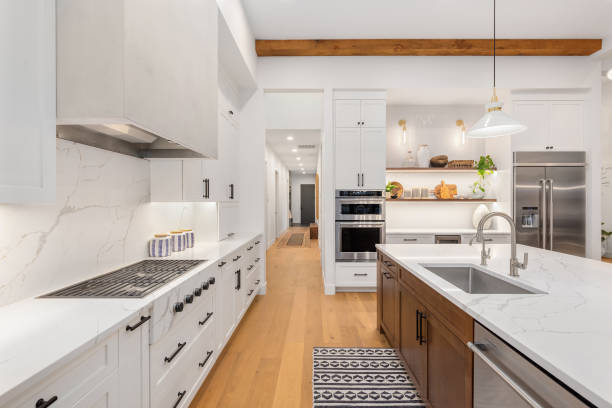 beautiful kitchen in new luxury home with island, pendant lights, and hardwood floors. - quartz imagens e fotografias de stock