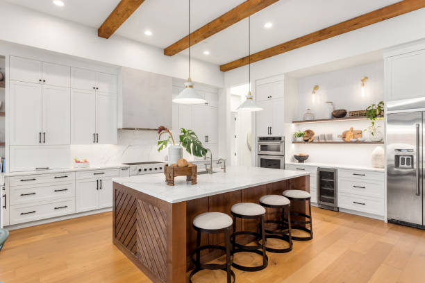 beautiful kitchen in new luxury home with island, pendant lights, and hardwood floors. - luxe stockfoto's en -beelden