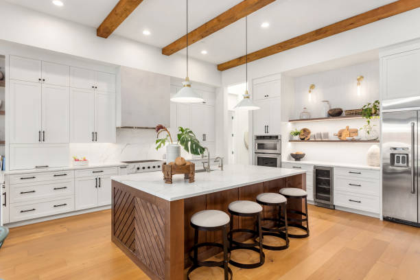 beautiful kitchen in new luxury home with island, pendant lights, and hardwood floors. - modern stok fotoğraflar ve resimler