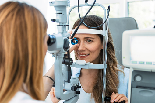 Beautiful young girl checking the eye vision in modern ophthalmology clinic