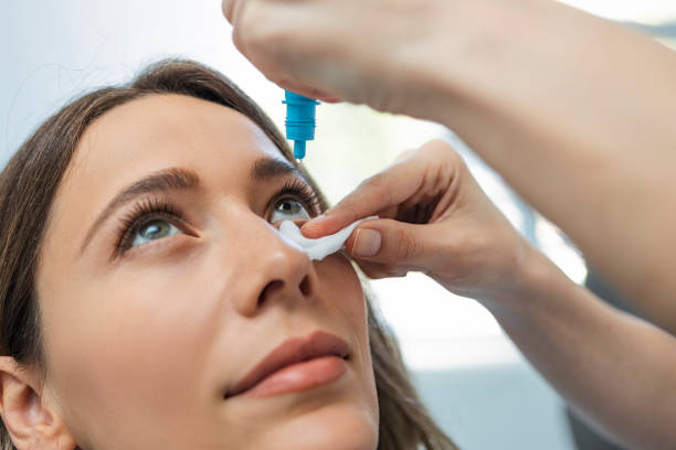 istock Ophthalmologist Using Eyedropper on a female patient 1398693488