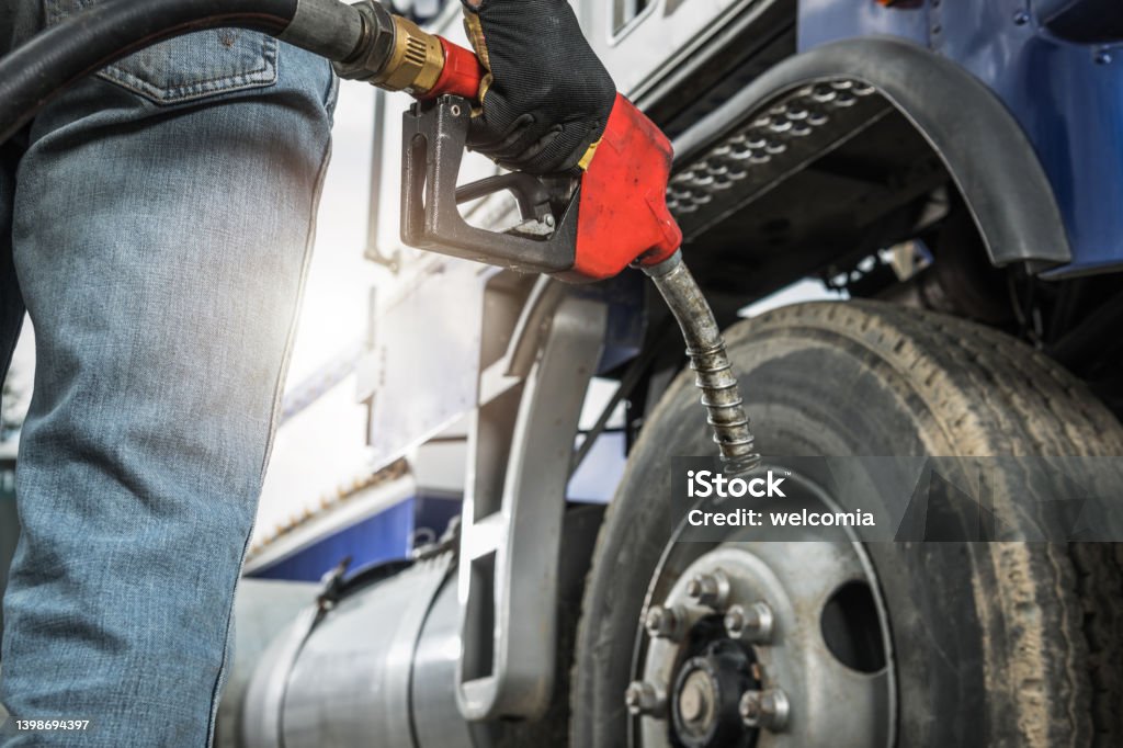 Semi Truck Driver About to Refuel His Tractor Truck with Diesel Fuel Aged Semi Truck Driver About to Refuel His Tractor Truck Holding Diesel Pump Nozzle in His Hand. Heavy Duty Transportation and Fuel Shortage Concept. Diesel Fuel Stock Photo