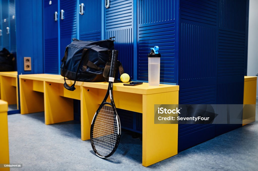 Sports Equipment in Locker Room Background image of tennis racket and sports equipment in locker room in vibrant blue color, copy space Locker Room Stock Photo