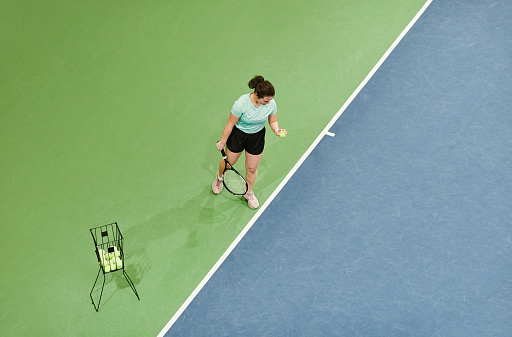 Front view of beautiful young female tennis player at backhand