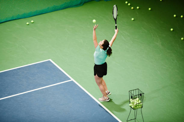 テニスをしている女の子の活気に満ちたショット - tennis indoors women court ストックフォトと画像