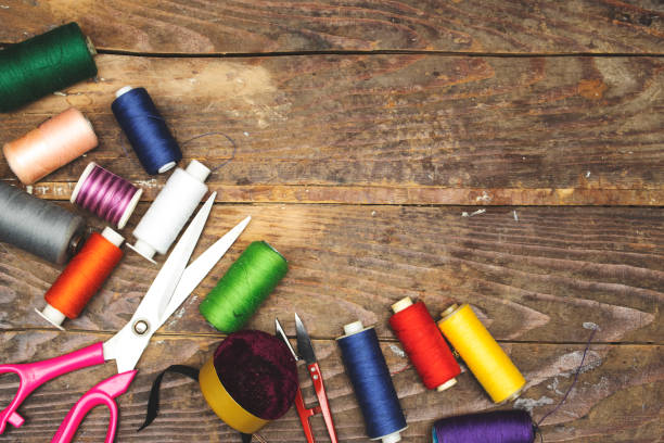 istock Spool of thread many of different colors and scissors on wood table 1398697174