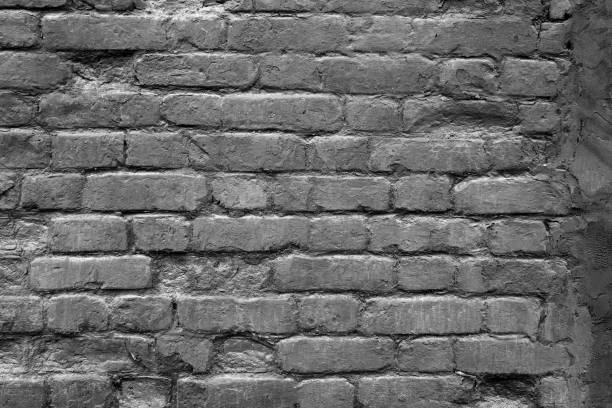 istock An old and damaged brick wall coated with black paint as a background 1398702705