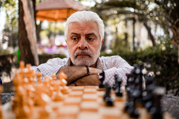 Close up of senior man and chessboard