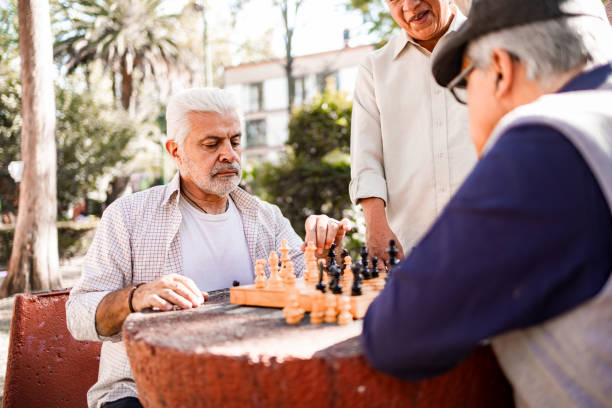 istock Senior men playing chess at the park 1398704368