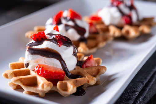 Homemade Waffle Dessert with Strawberries, Whipped Cream and Chocolate Syrup
