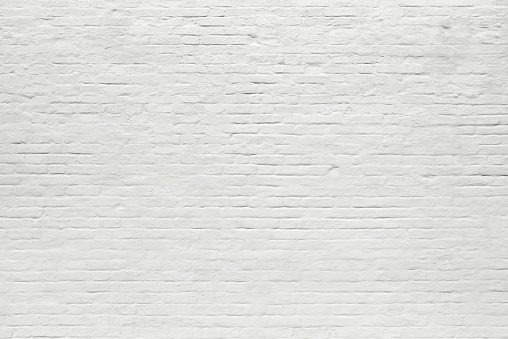 Old painted white brick grunge wall texture background, full frame. Loft-style wall