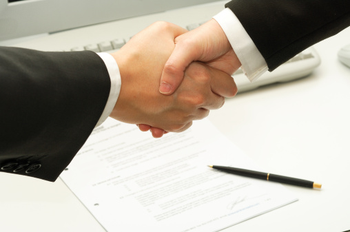 business man shake hands after signing a contract