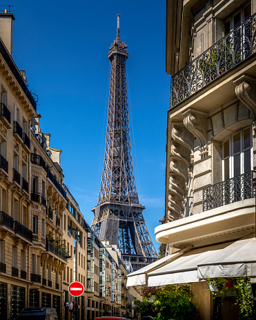 Paris, France - May 27, 2021: Eiffel tower between haussman buildings in Paris