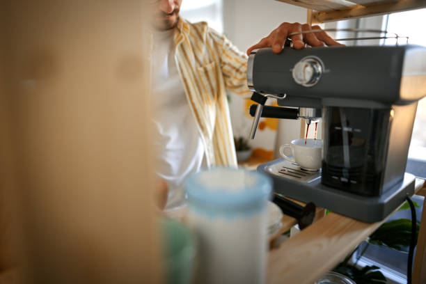 istock Casually clothed man preparing a coffe on a coffee machine in his home office 1398708691