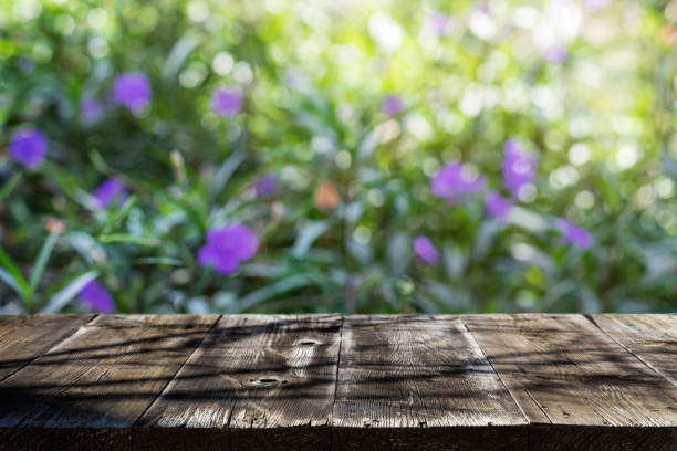 istock Empty wooden table with shadow of trees in outdoor. 1398709918