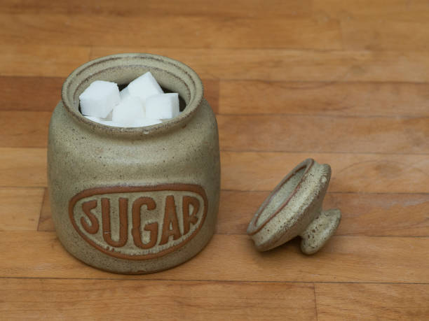 Sugar jar with cubes on wooden worktop