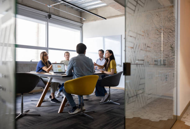 group of business people talking in a meeting at the office - peeking imagens e fotografias de stock