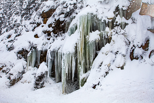Winter scene of icicles hanging from a snow covered mountain