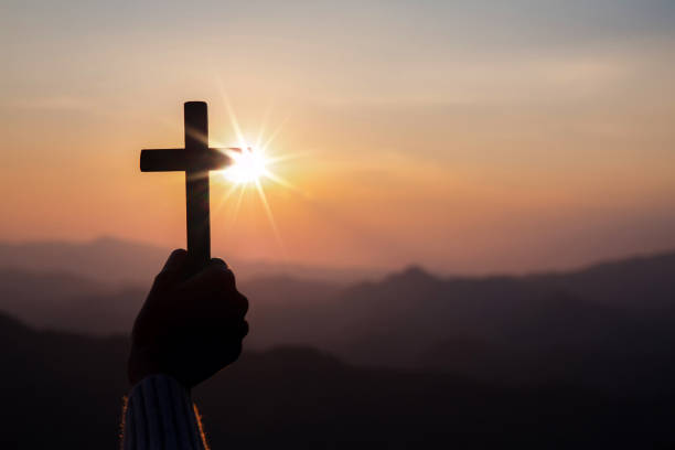 istock silhouette hand holding cross 1398723428