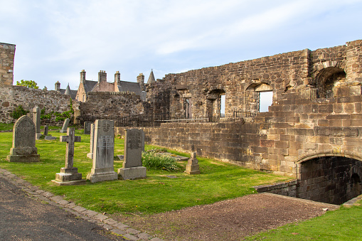 Stirling, Scotland, United Kingdom - April 28, 2022: View of medieval wall ruins along the cemetery grounds of the Church of the Holy Rude. Gravestones date to the 16th century.