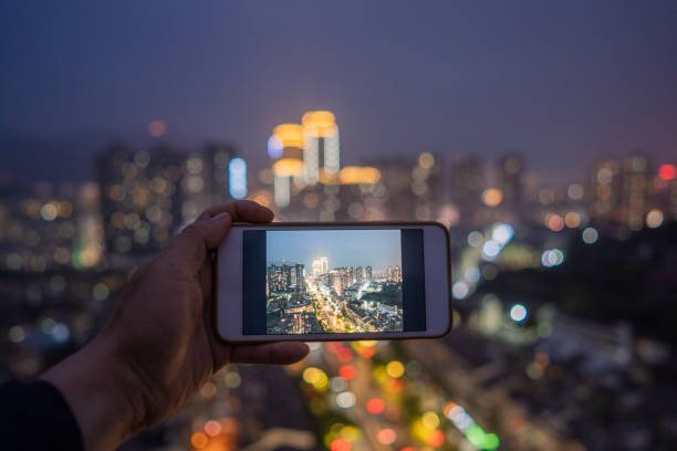 istock Hand shooting city night scene with mobile phone 1398726674