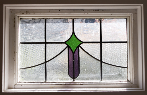 a small stained glass window with green and purple sections