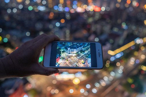 Hand shooting city night scene with mobile phone