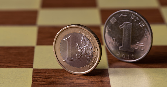 Coins of 1 Euro and 1 Chinese Yuan on a chessboard