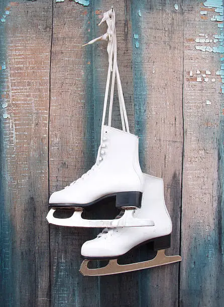Ice skates hanging on weathered door