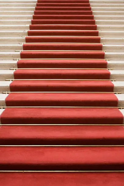 Red carpet on marble stairway welcoming VIPs.