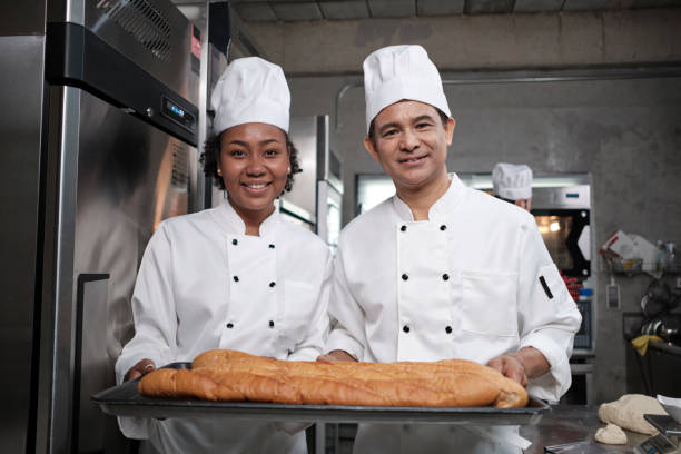 istock Two professional chefs with baking bread, smile and are cheerful in the kitchen. 1398738247