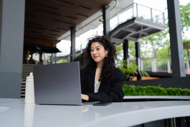 istock Businesswoman working while sitting at park. 1398738937