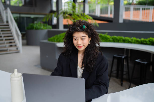 istock Businesswoman working while sitting at park. 1398738943