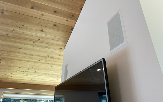 Music audio speakers mounted in wall above television