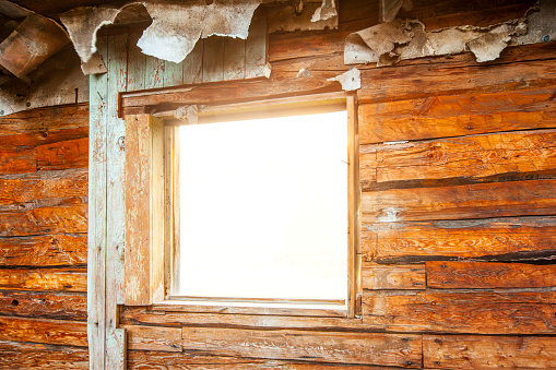Old wooden cabin framed window looking out into pure white background. Vintage, rustic wood theme.
