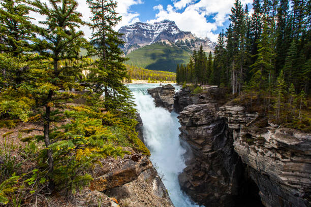 istock Snow capped rocky mountain landscape scene with powerful waterfall into rocky gorge 1398743698