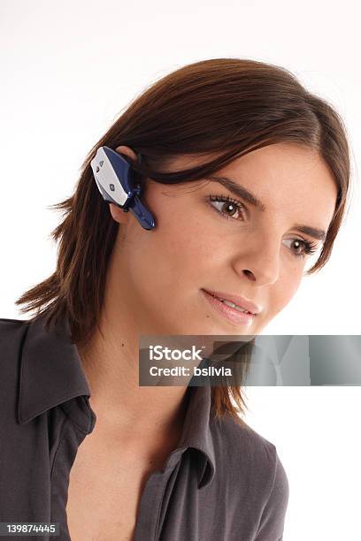 Foto de Jovem Mulher Usando Fone De Ouvido Bluetooth e mais fotos de stock de 20 Anos - 20 Anos, Adulto, Agente de atendimento ao cliente