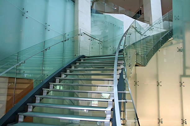 Glass stairs with metal handrails seen from below