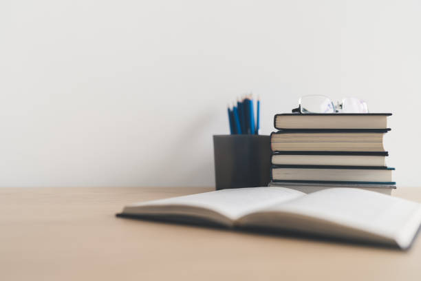 istock Open book and stack of textbook on table. Business success idea of learning, planning or working. Education concept of studying and knowledge cognition. Businessperson or student training skill 1398745607