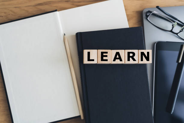 istock Wooden cube word LEARN with laptop, table and book or textbook. Business learning or education knowledge idea concept 1398745661