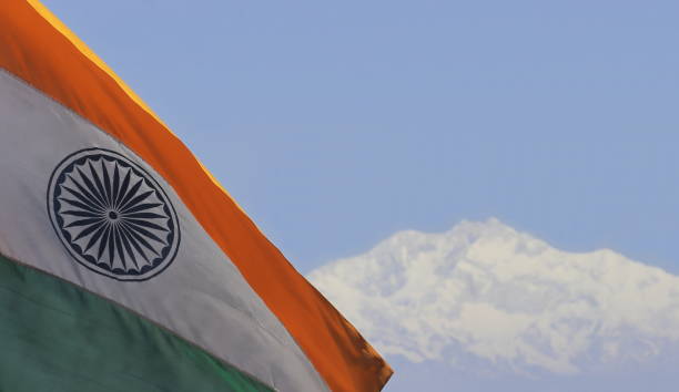 waving tri color indian national flag with indian highest mountain peak mount kangchenjunga in the background waving tri color indian national flag with indian highest mountain peak mount kangchenjunga in the background kangchenjunga stock pictures, royalty-free photos & images