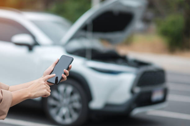 istock woman driver using mobile phone during problem car. Breakdown or broken car on road. Vehicle Insurance, maintenance and service concept 1398748264